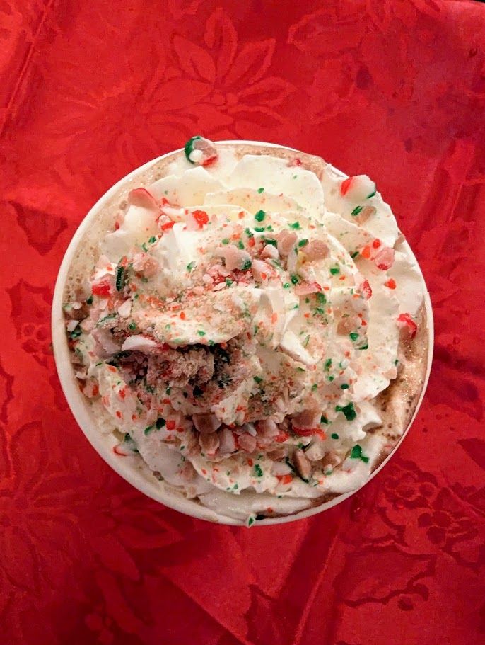 A festive drink topped with whipped cream and crushed candy cane