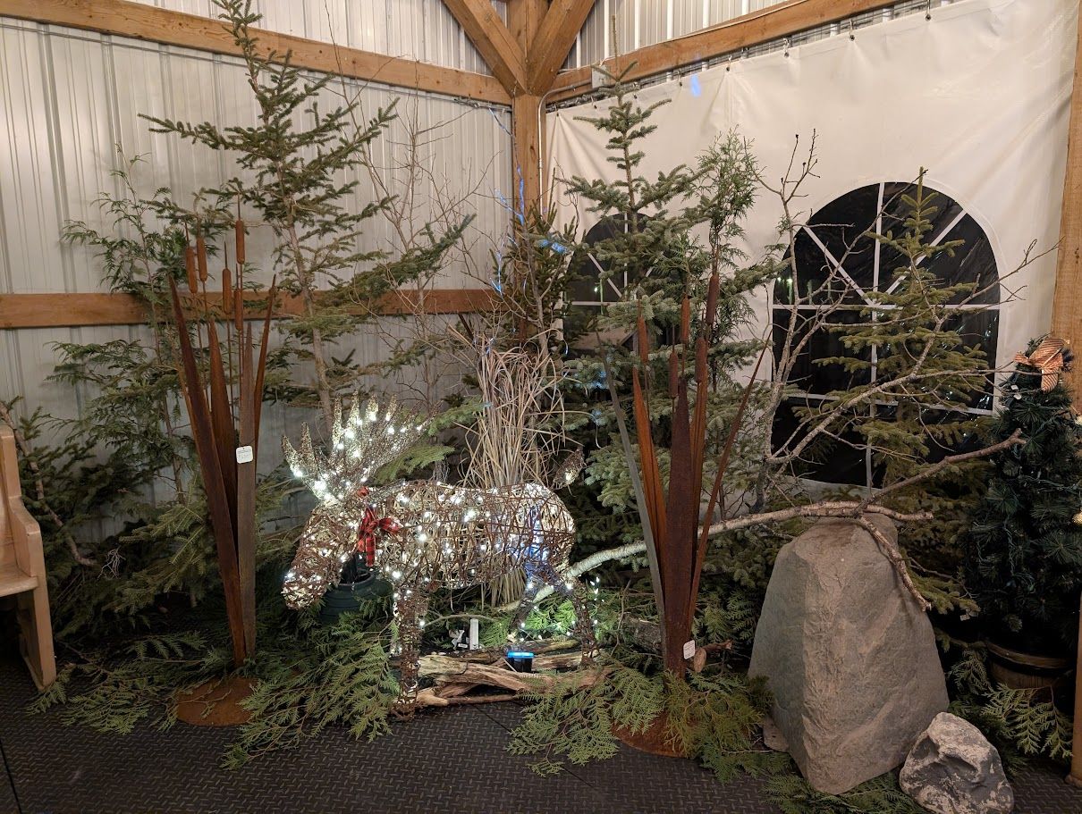 A themed winter scene with a glittering moose and evergreen trees inside the covered tent